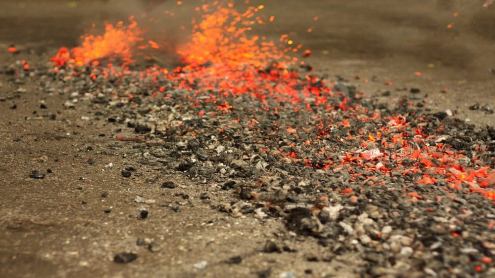 A bed of coals prepared for a fire walk, a trial by fire.